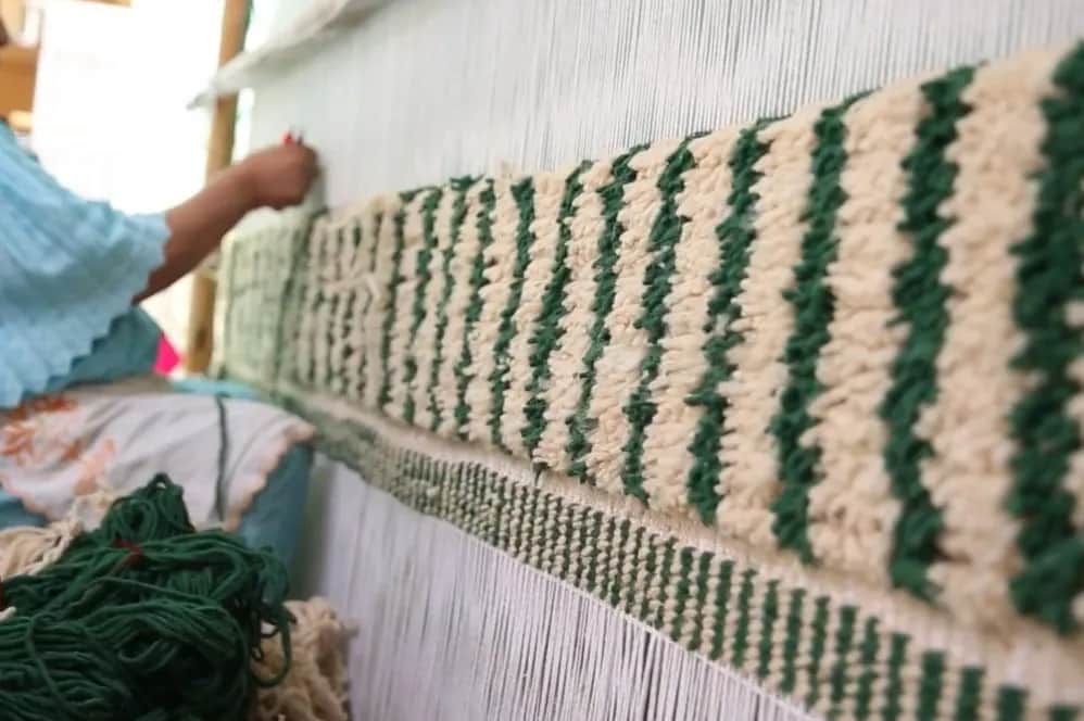 Moroccan artisan weaving a Berber rug