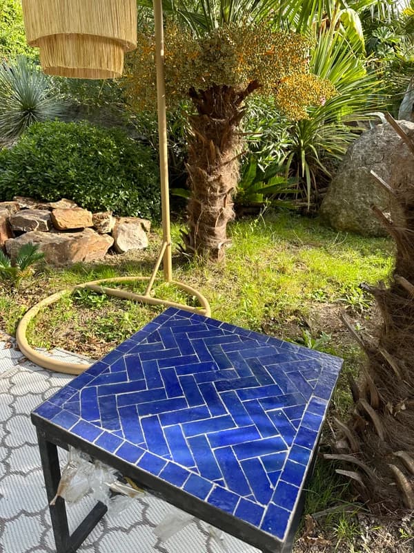 Cobalt blue Zellige table among garden plants